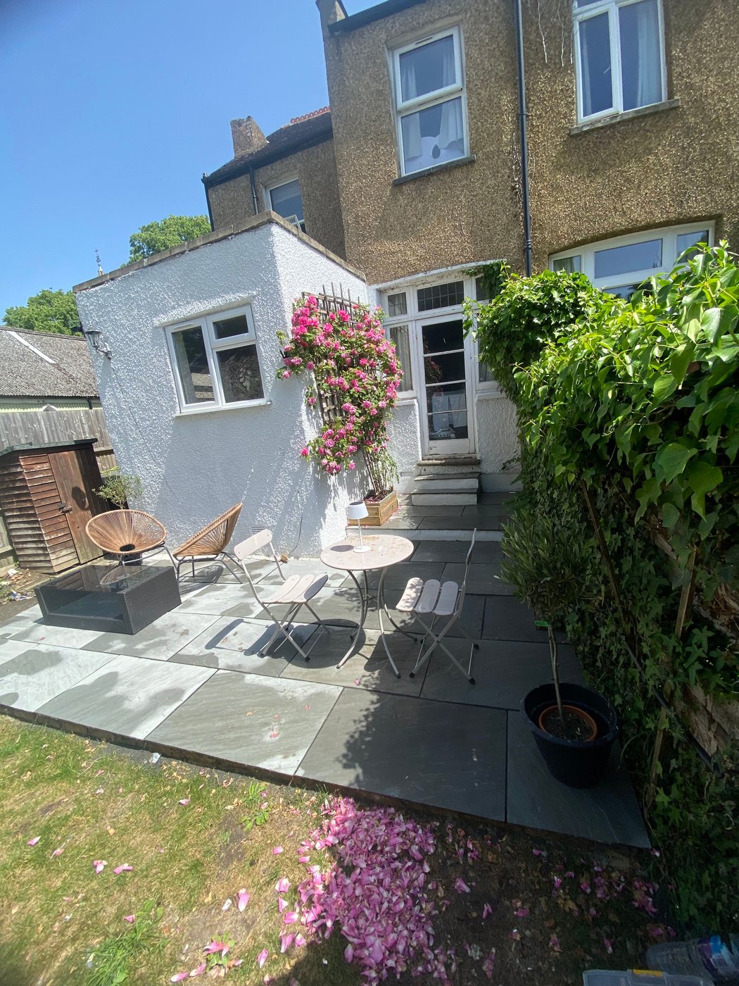 Landscaped slate patio with seating area by White&Son Services